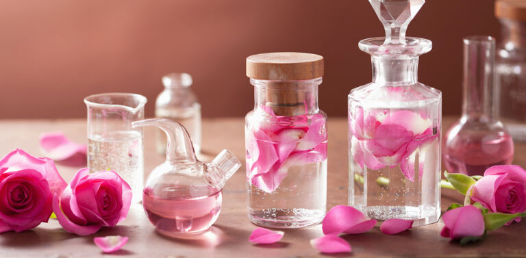 alchemy and aromatherapy set with rose flowers and flasks