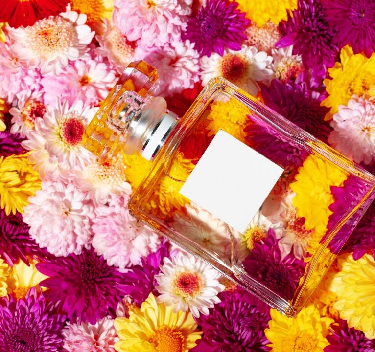 Bottle of fragrance surrounded by flower